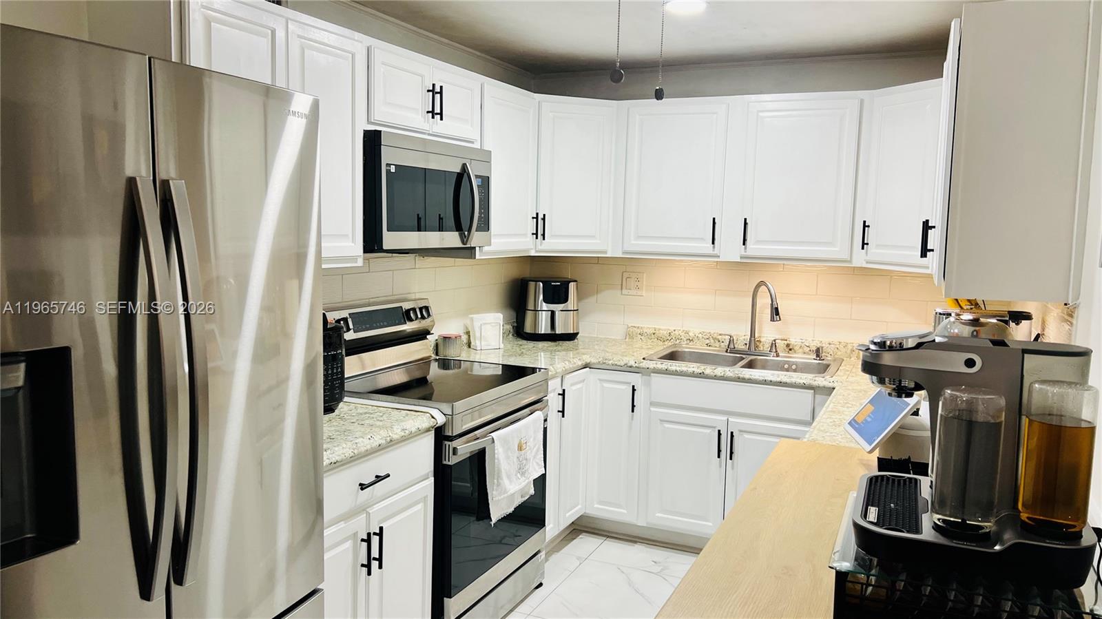 14250 Southwest 62nd Street, Unit 319 Miami, FL 33183 - Photo 6 of 29 a kitchen with stainless steel appliances granite countertop a refrigerator sink and stove