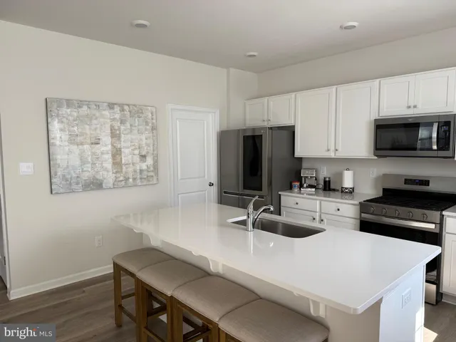 a kitchen with sink a microwave a refrigerator and cabinets