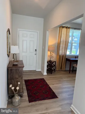 a living room with furniture a large window and wooden floor