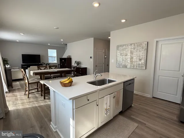 a kitchen with white cabinets and sink