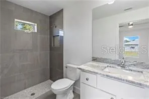 a bathroom with a granite countertop sink toilet and shower
