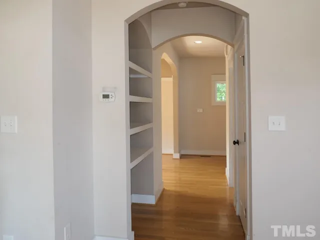 a view of a hallway with wooden shelves
