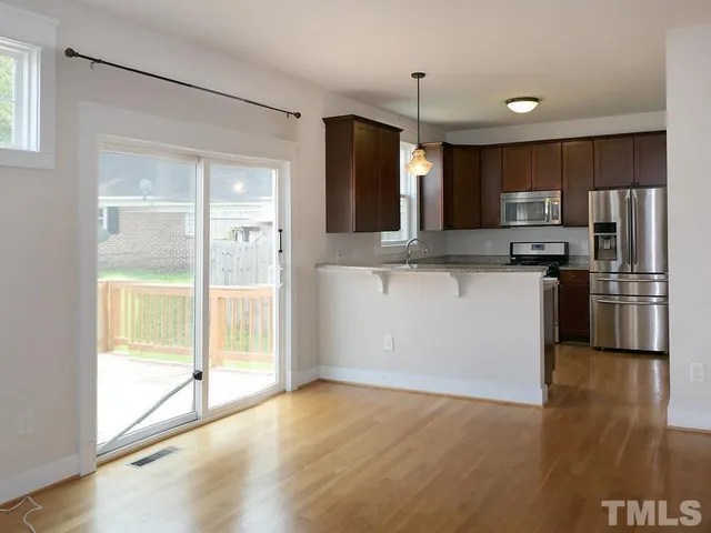 a kitchen with stainless steel appliances granite countertop a refrigerator and a stove top oven