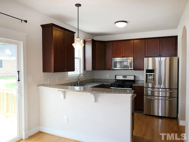 a kitchen with kitchen island a counter top space stainless steel appliances and cabinets