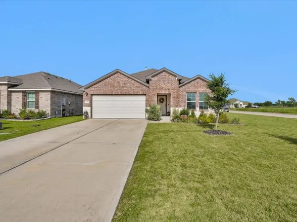 a front view of a house with a garden and yard