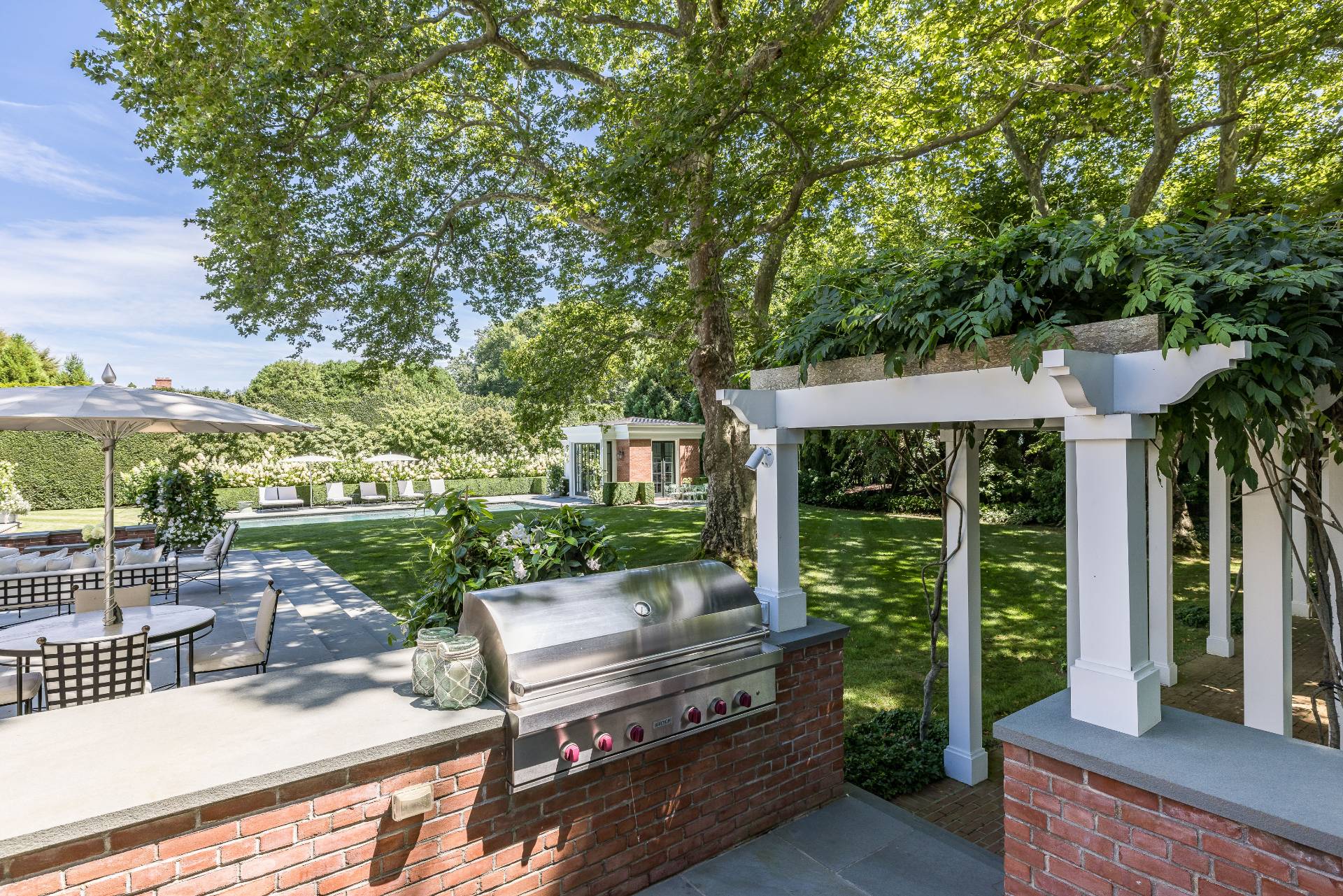 43 Lee Avenue East Hampton, NY 11937 - Photo 13 of 49 a view of a patio with table and chairs potted plants and a large tree