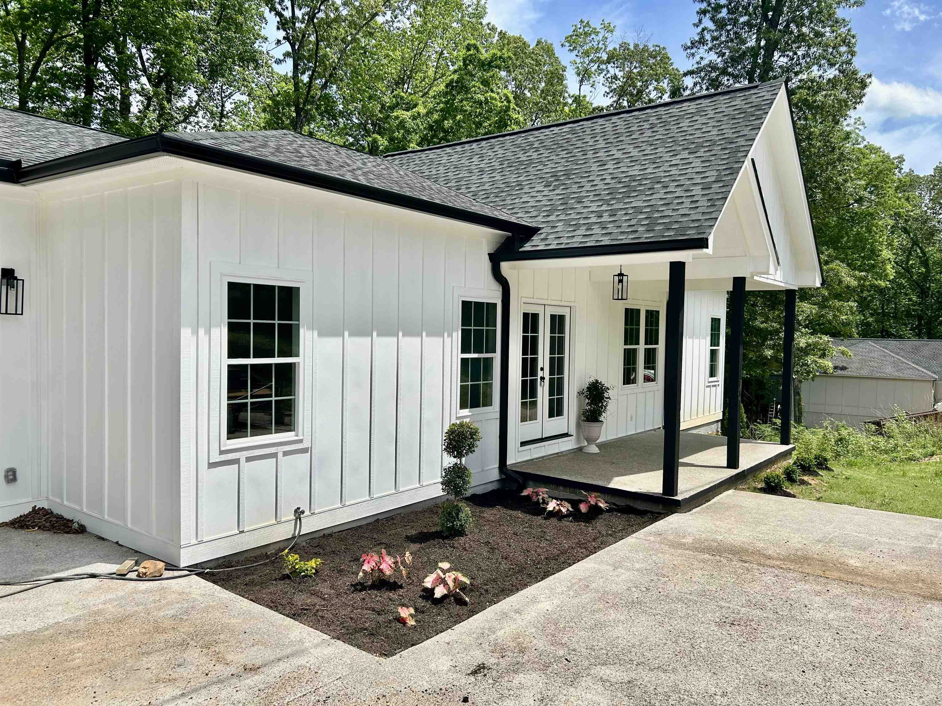 Exterior space with a shingled roof, board and batten siding, and french doors