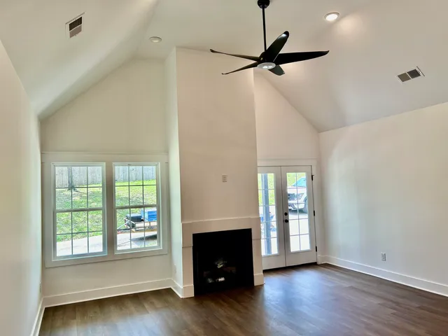 a view of empty room with a fireplace and wooden floor