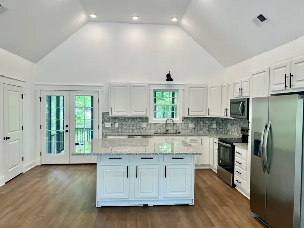 a bathroom with a granite countertop sink a toilet and bathtub