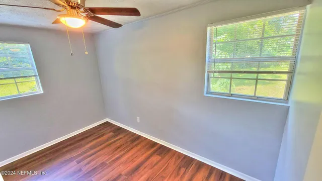 an empty room with a window and wooden floor