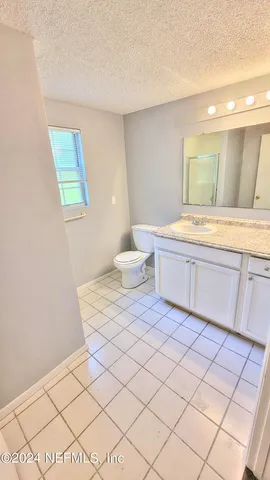 a bathroom with a sink mirror vanity and toilet