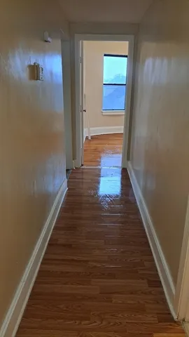 a view of a hallway with wooden floor