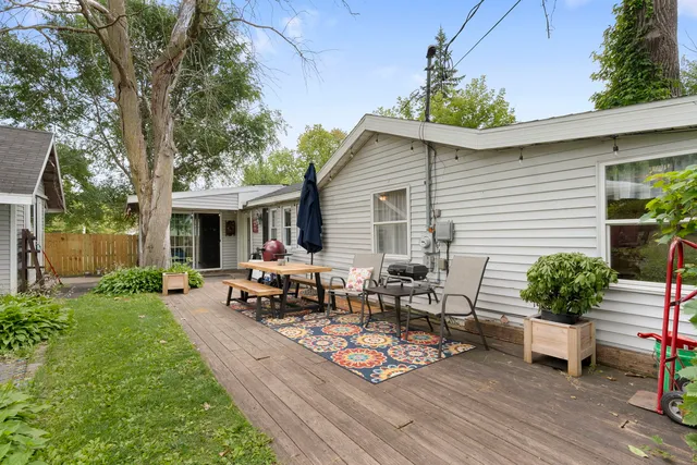 a view of a patio with table and chairs potted plants and a large tree