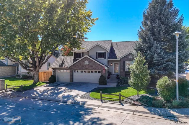 a front view of house with a garden and trees