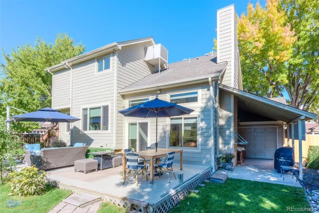 a patio with a table and chairs under an umbrella