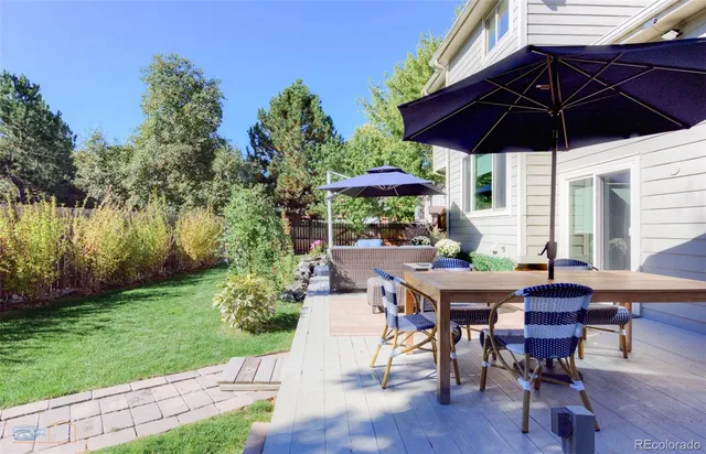 a view of a patio with table and chairs under an umbrella
