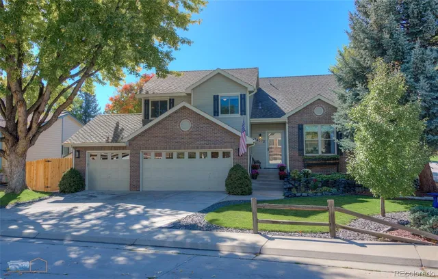 a front view of a house with a garden and yard