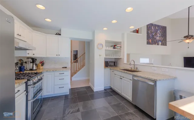 a kitchen with granite countertop a sink stove and cabinets