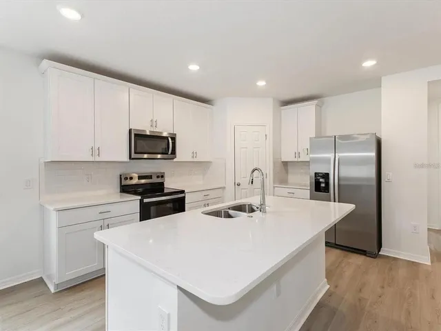 a kitchen with refrigerator cabinets and wooden floor