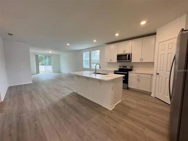 a kitchen with stainless steel appliances a refrigerator sink and microwave