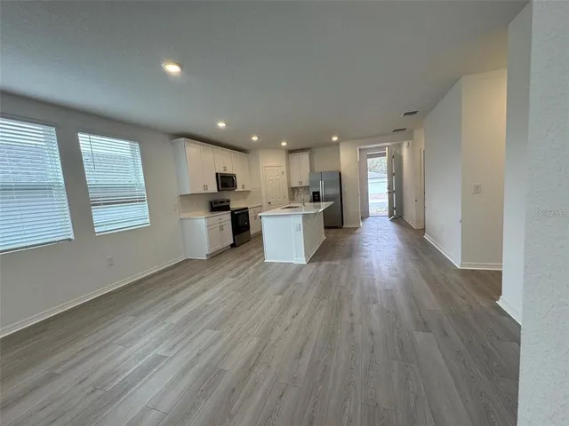 a view of a kitchen with a sink and wooden floor