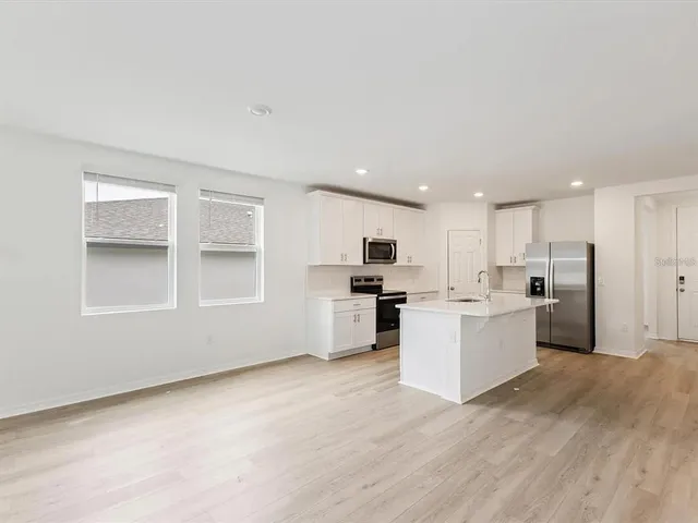 a view of a kitchen with wooden floor and windows