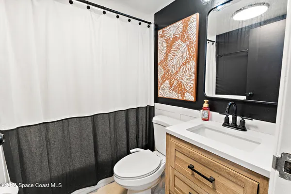 a bathroom with a sink a toilet and mirror