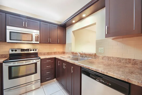 a kitchen with granite countertop cabinets stainless steel appliances and a sink