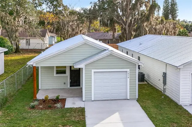 a view of house with backyard and trees