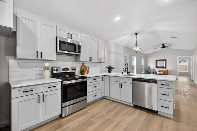 a kitchen with white cabinets and stainless steel appliances