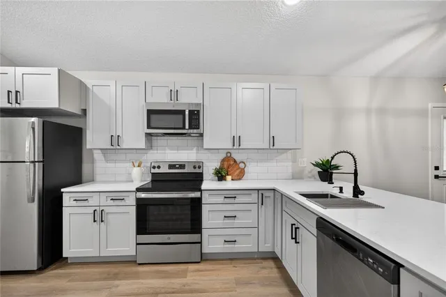 a kitchen with white cabinets and stainless steel appliances