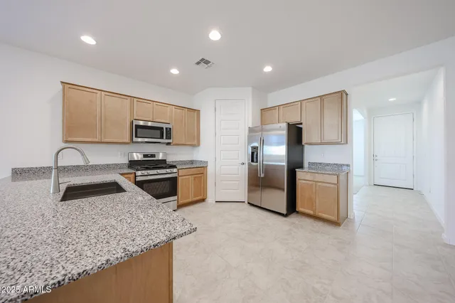 a kitchen with stainless steel appliances granite countertop a sink refrigerator and microwave