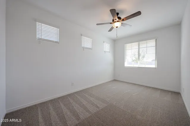 an empty room with a window and a ceiling fan