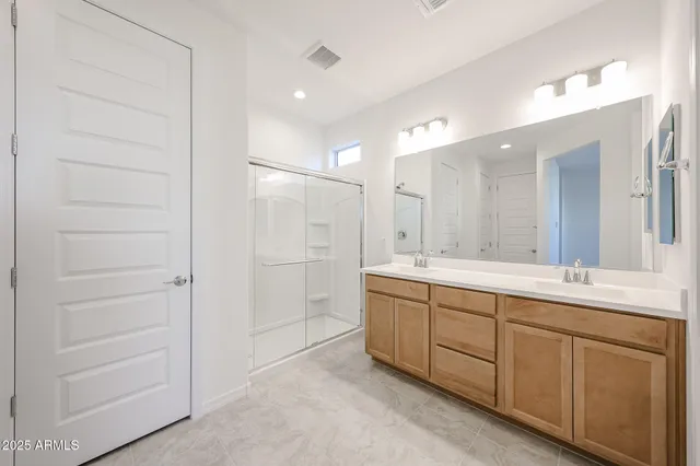 a bathroom with a double vanity sink and a mirror