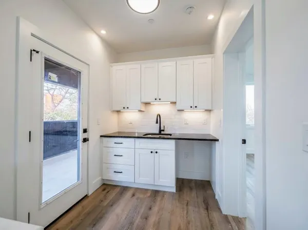 a kitchen with granite countertop white cabinets and white appliances