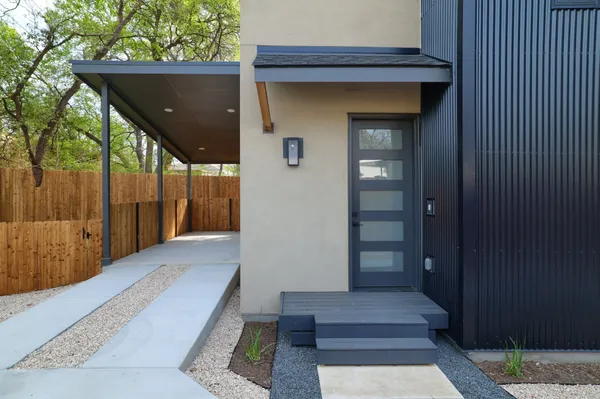 a large white kitchen with stainless steel appliances granite countertop a stove and wooden floor