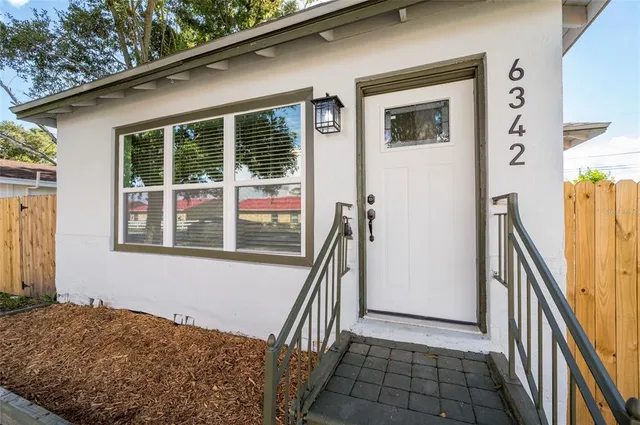 a view of an empty room with a fireplace and a window