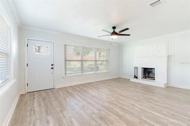 an empty room with fan and windows