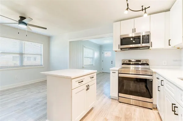 a kitchen with stainless steel appliances a sink a stove a microwave and cabinets