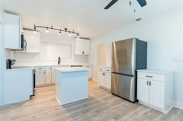a kitchen with a sink cabinets and wooden floor