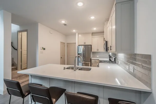 a kitchen with kitchen island a sink and a refrigerator