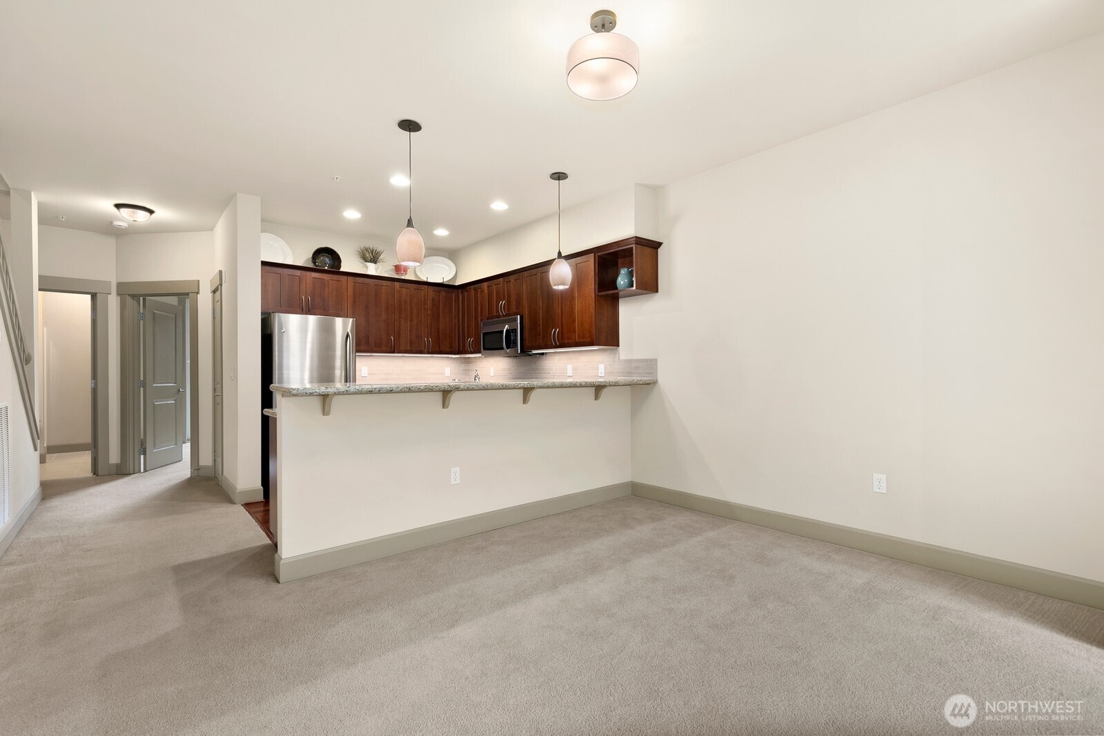 2115 201st Place Southeast, Unit H3 Bothell, WA 98012 - Photo 8 of 37 an empty room with a kitchen and a chandelier fan
