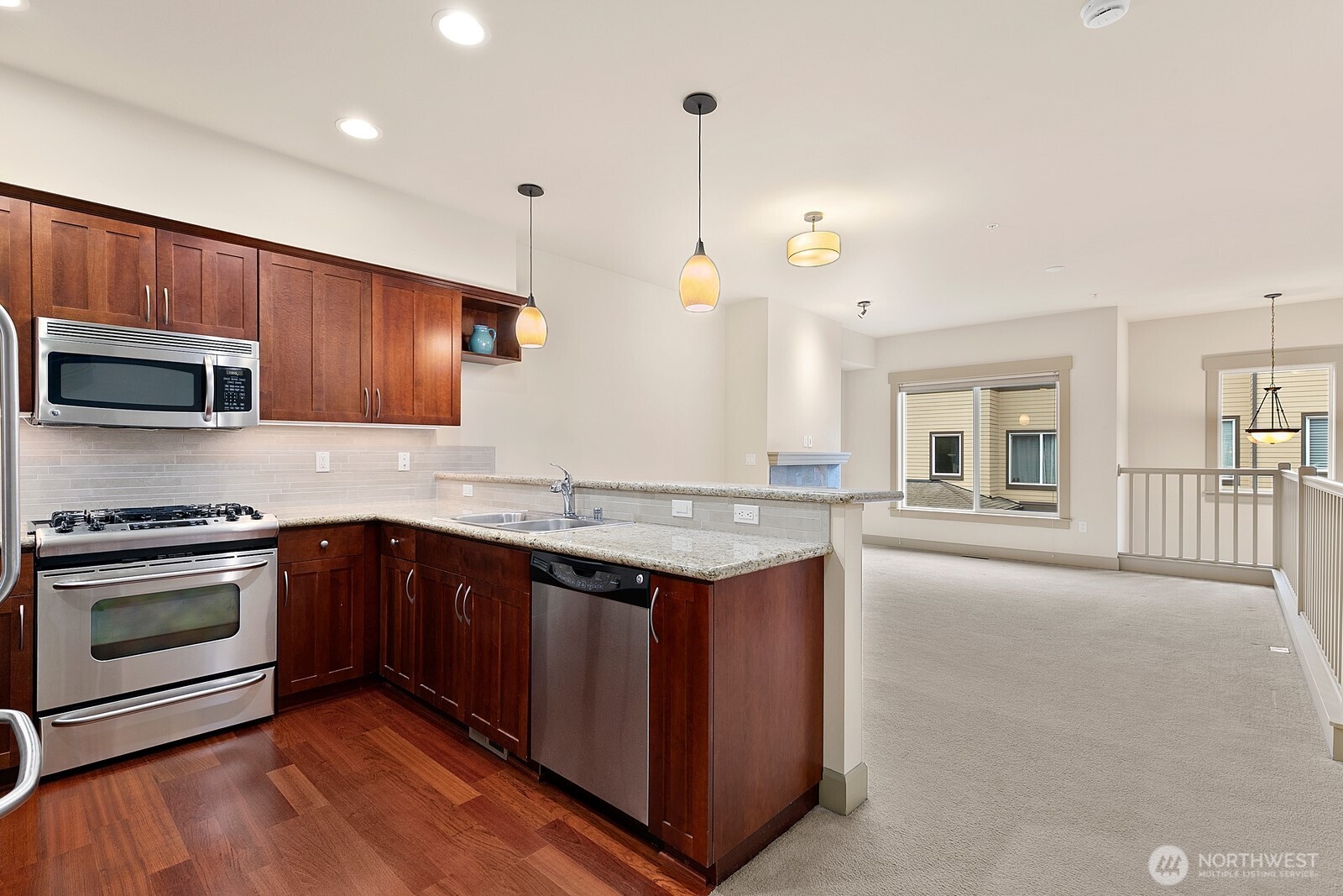 2115 201st Place Southeast, Unit H3 Bothell, WA 98012 - Photo 10 of 37 a kitchen with stainless steel appliances granite countertop a stove a sink and a microwave