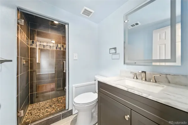 a bathroom with a sink a toilet and shower