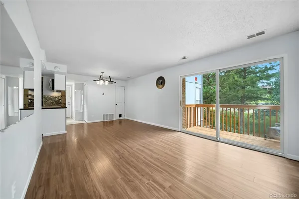 a view of an empty room with wooden floor