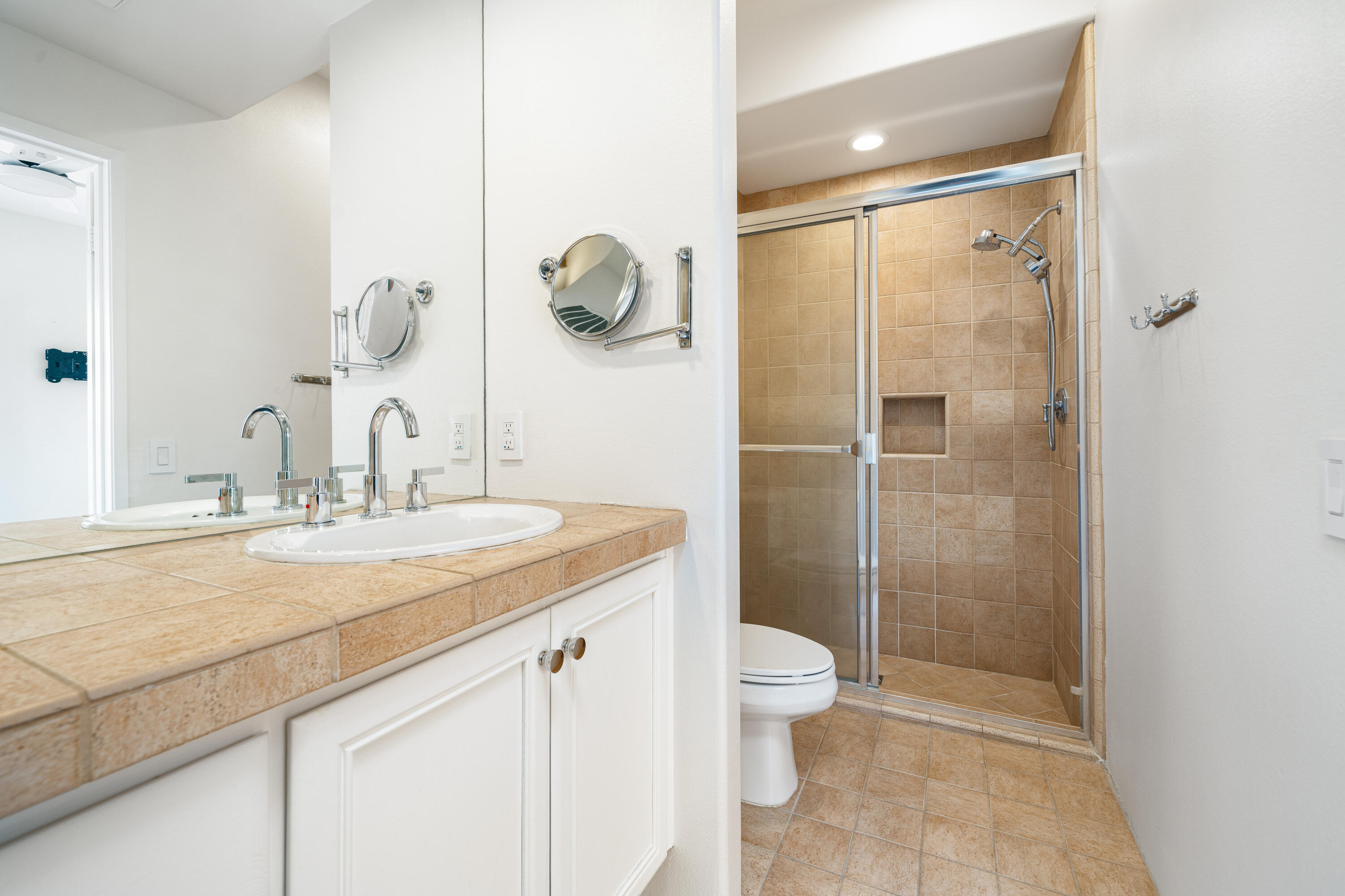 79060 River Rock Road La Quinta, CA 92253 - Photo 28 of 36 a bathroom with a granite countertop sink a toilet a mirror and shower