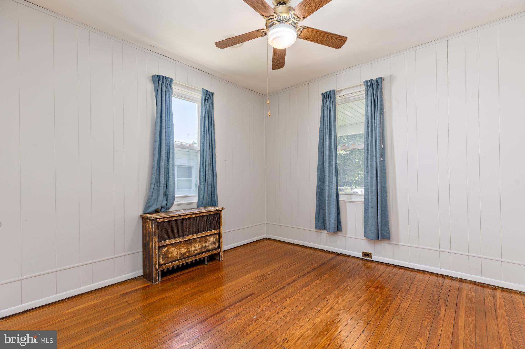 6426 Sherwood Road Baltimore, MD 21239 - Photo 22 of 43 an empty room with wooden floor fan and windows