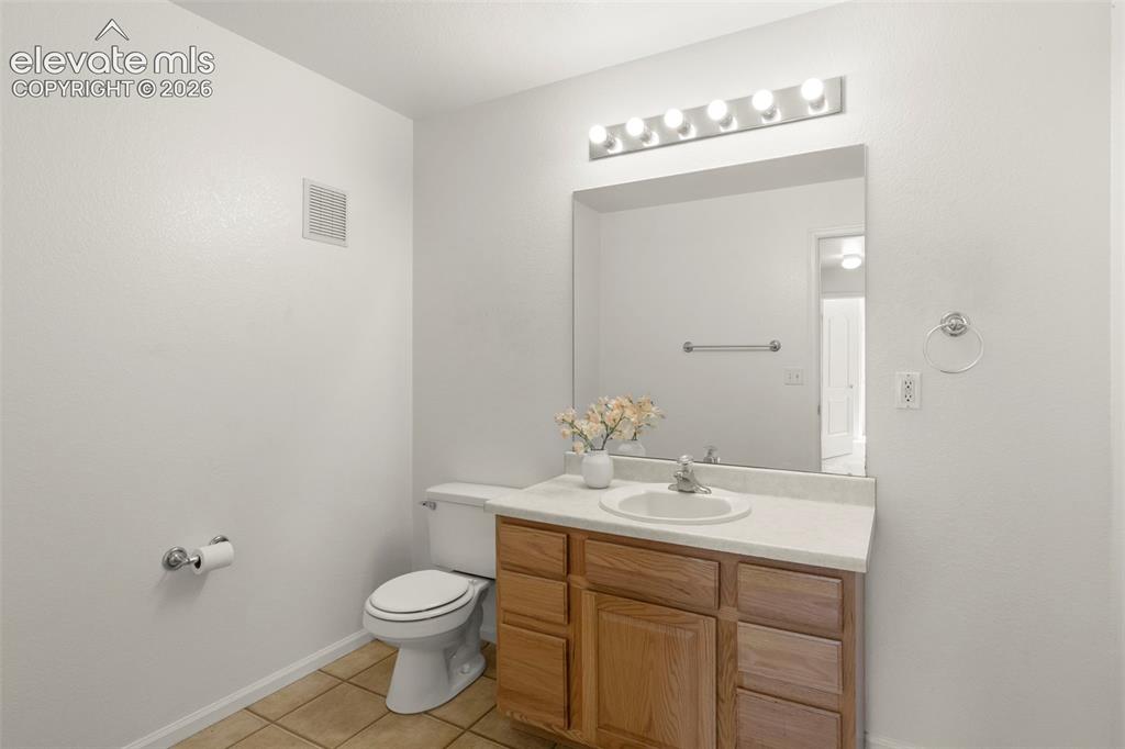1563 Monterey Road, Unit D Colorado Springs, CO 80910 - Photo 13 of 22 a bathroom with a sink a toilet and mirror