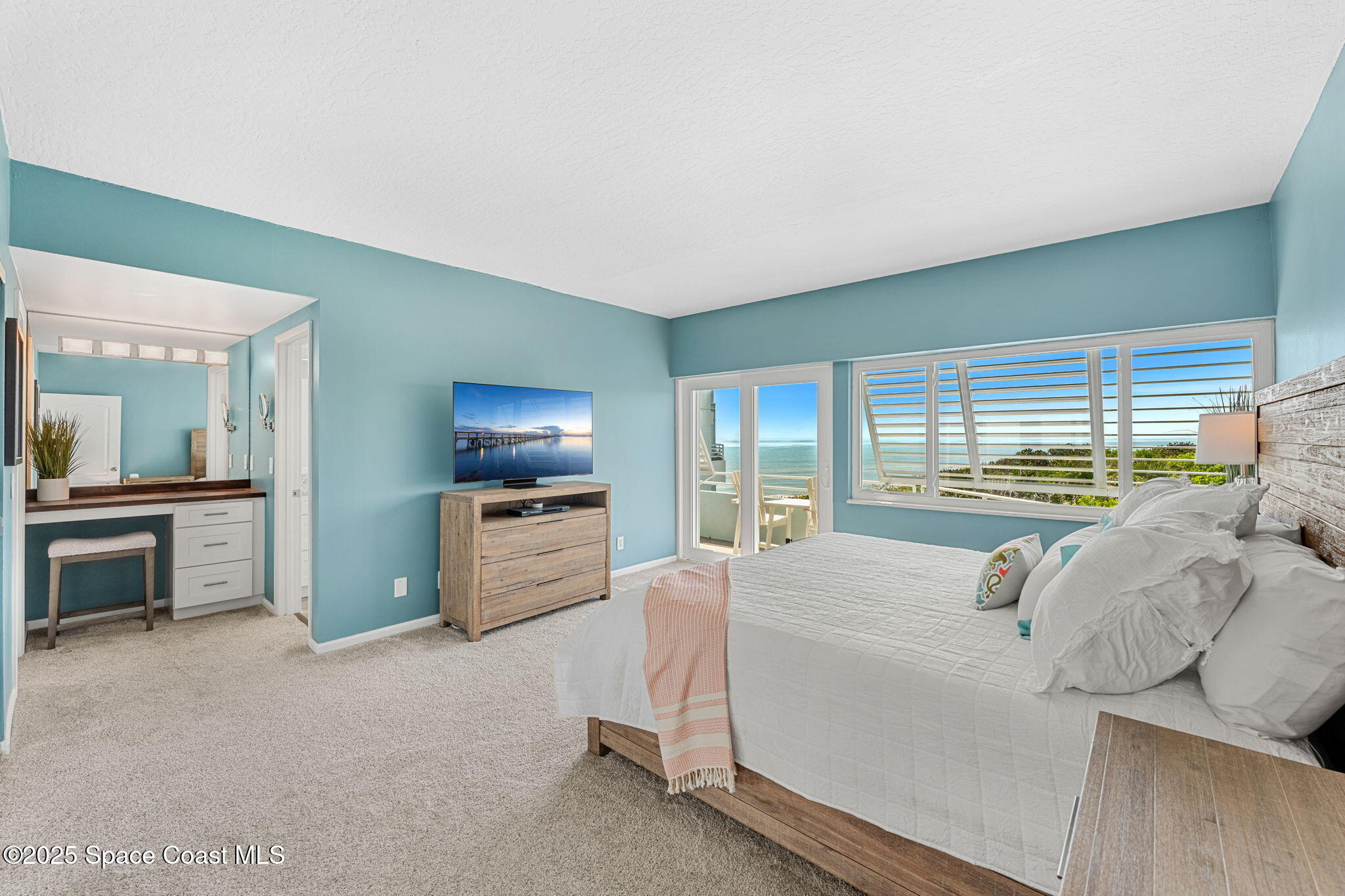 6355 South Hwy A1A, Unit 5 Melbourne Beach, FL 32951 - Photo 13 of 37 a bedroom with a bed and a television in the background