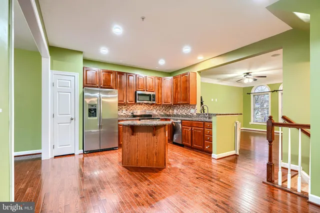 a kitchen with stainless steel appliances granite countertop a refrigerator and a stove top oven